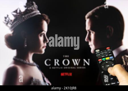 Belgrado, Serbia - 12 settembre 2022: Guardare la TV Show la corona su Netflix con telecomando in mano. La serie TV è circa la famiglia reale britannica e. Foto Stock