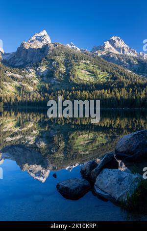 Le montagne Teton si riflettevano in uno specchio riflesso nelle acque ferme del lago Bradley. Grand Teton National Park, Wyoming Foto Stock