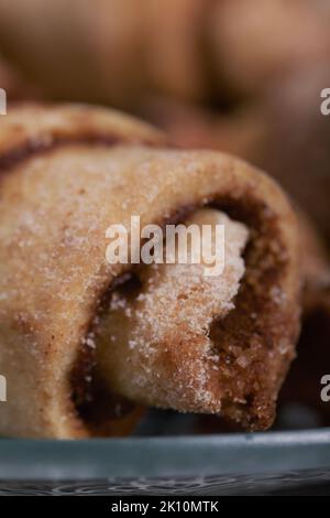 Panini con cannella. Croissant alla cannella. Giacciono su un piattino. Primo piano. Foto Stock