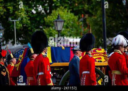 Whitehall, Londra, Regno Unito, 14th settembre 2022, la bara di sua Maestà la Regina, sopportata su una carrozza della pistola drappeggiata con lo Standard reale, con la corona di Stato imperiale e la corona di Rose bianche, le dahlias bianche, la lavanda e il rosmarino che viaggiano verso Westminster Hall. Chrysoulla Kyprianou Rosling/Alamy News Foto Stock