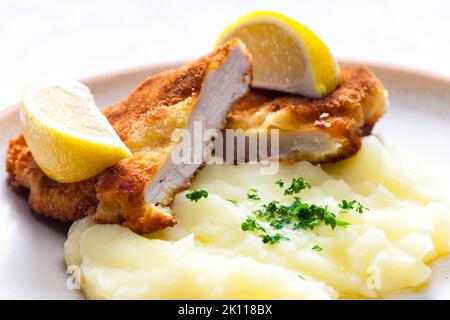 schnitzel di pollo con purè di patate e limone Foto Stock