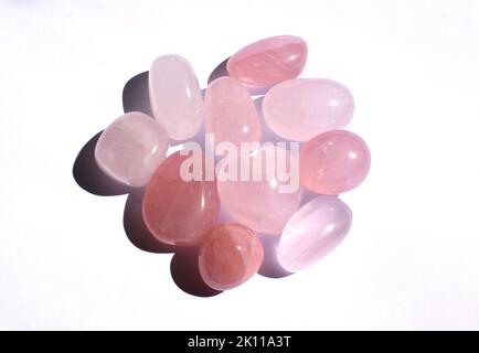 Molte pietre rotonde di quarzo rosa lucidate. Cristalli di quarzo rosa a forma di cuore. Minerali semi-preziosi - un talismano d'amore per le donne. Foto Stock