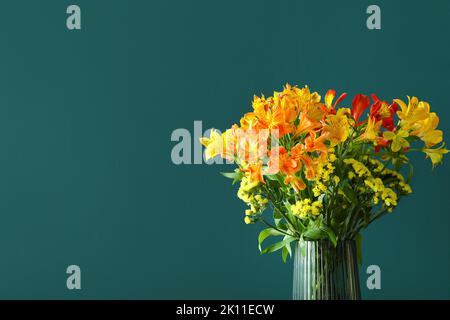 Vaso con bouquet di bellissimi fiori di alstroemeria vicino al muro verde Foto Stock