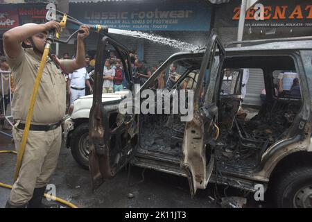 KOLKATA, INDIA - 13 SETTEMBRE: Un personale dei vigili del fuoco cerca di destare un furgone di polizia che ha preso fuoco durante la protesta dei membri del Bharatiya Janata Party (BJP) e dei sostenitori contro la presunta corruzione da parte dei leader del Trinamool Congress (TMC) il 13 settembre 2022 a Kolkata, India. Molti leader e sostenitori del BJP sono stati feriti in carica dalla polizia. Anche alcuni leader del BJP, tra cui il capo di stato del partito Sukanta Majumdar e Suvendu Adhikari, che hanno partecipato alla marcia, sono stati arrestati dalla polizia insieme ai loro sostenitori. Udienza al motivo della BJP contro alti funzionari del governo statale Foto Stock