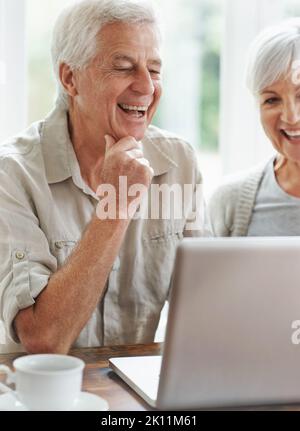 Ritrovarsi con i bambini. Una coppia giovane allegra che ha una videochat su un computer portatile. Foto Stock