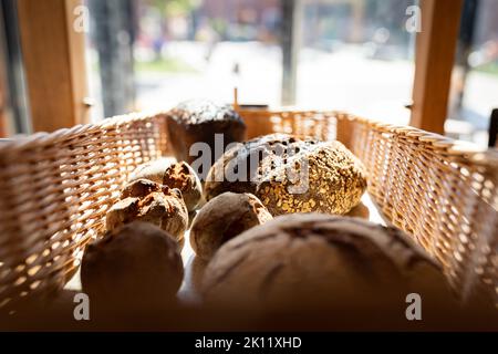 Pane artigianale pronto con semi sul banco in una piccola panetteria. Vista frontale. Foto Stock