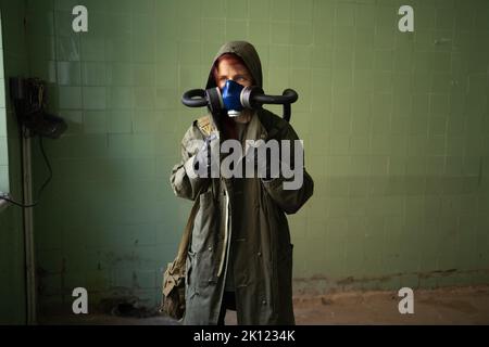 Sopravvivenza femminile post-apocalisse in maschera a gas su sfondo parete. Spazio di copia. Inquinamento atmosferico, disastro ambientale Foto Stock