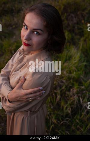 Donna felice cammina al tramonto su un parco collina Foto Stock