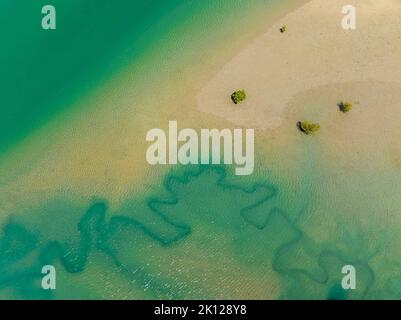 Vista aerea drone giù sull'oceano con la bassa marea con acqua verde e sabbia dorata. Grasstree Beach Queensland Australia. Foto Stock