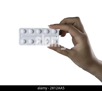 una confezione blister di pillole nella mano femminile su sfondo bianco Foto Stock