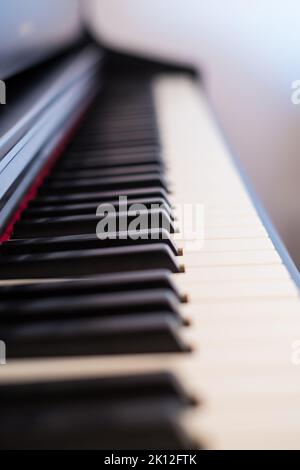Primo piano della classica tastiera per pianoforte a coda. Primo piano di un pianoforte in legno e di tasti per pianoforte. Messa a fuoco selettiva e messa a fuoco morbida. Vista frontale, profondità di campo ridotta Foto Stock