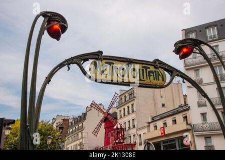 Parigi, Francia. Agosto 2022. Il caratteristico segno metropolitano con il Moulin Rouge sullo sfondo. Foto di alta qualità Foto Stock