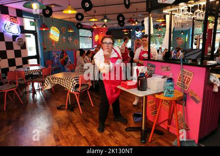 Un membro del personale che alza il dito contro il Karen’s Diner di Prestwich, Manchester. Karen's non è per i deboli di cuore, ma è il luogo perfetto per torto Foto Stock