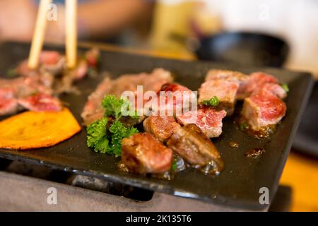 Tagliare a dadini il manzo sulla padella calda, concentrandosi in modo selettivo Foto Stock