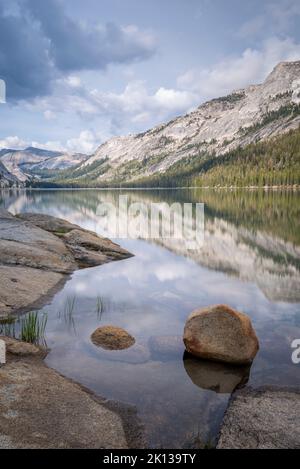 Riflessioni di montagna nelle acque tranquille del lago Tenaya nel Parco Nazionale di Yosemite Foto Stock