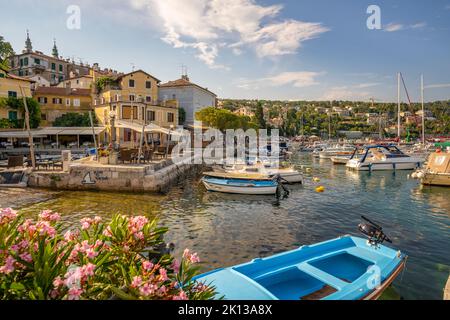 Vista delle barche nel porto turistico e ristoranti sul porto durante l'ora d'oro a Volosko, Opatija, Quarnero, Croazia, Europa Foto Stock