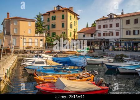 Vista delle barche nel porto turistico e ristoranti sul porto durante l'ora d'oro a Volosko, Opatija, Quarnero, Croazia, Europa Foto Stock