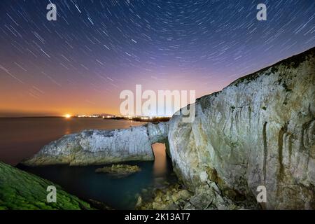 Star trail e cielo notturno su BWA Gwyn o l'Arco Bianco, vicino a Rhoscolyn, Anglesey, Galles del Nord, Regno Unito, Europa Foto Stock