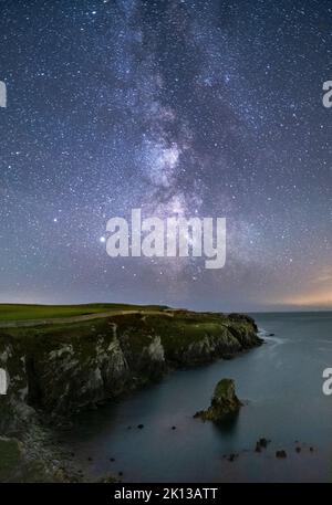 La Via Lattea e il cielo notturno sopra Gwenfaens Pillar, Porth Saint, vicino a Roscolyn, Anglesey, Galles del Nord, Regno Unito, Europa Foto Stock