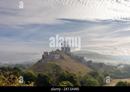 Vista del castello di Corfe nell'isola di Purbeck, Dorset, Inghilterra in una mattina misteriosa a settembre Foto Stock