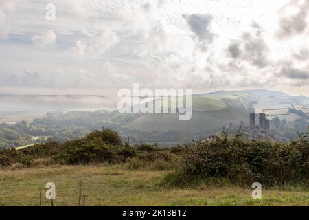Vista della campagna del Dorset a Corfe in una mattinata misteriosa con le rovine del castello in lontananza, Inghilterra, Regno Unito Foto Stock