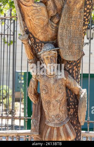 Particolare della statua di Don Chisciotte scolpita nel tronco di un albero. Il testo fa parte del libro di Don Miguel de Cervantes, Don Chisciotte de la Mancha Foto Stock