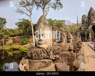 Teste di pietra scolpite all'ingresso di Angkor Thom, Siem Reap, Cambogia Foto Stock