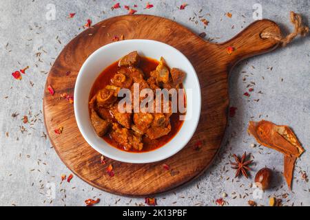 Fuoco selettivo del curry di monton indiano delizioso con uno sfondo decorativo. Foto Stock