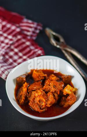 Fuoco selettivo del curry di monton indiano delizioso con uno sfondo decorativo. Foto Stock