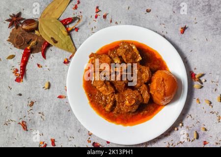 Fuoco selettivo del curry di monton indiano delizioso con uno sfondo decorativo. Foto Stock