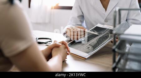 Medico che mostra il risultato radiologico al paziente in clinica Foto Stock