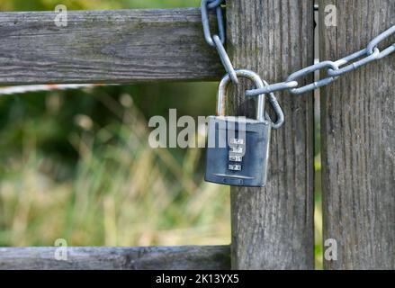 Una serratura su una recinzione di legno con un codice Foto Stock