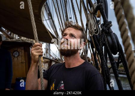 La nave a vela da carico «Tres Hombres» della compagnia marittima «Fairtransport» è ormeggiata nel suo porto di origine a Den Helder, Paesi Bassi, e salpa le vele. Qui viene preparato dall'equipaggio per il suo prossimo viaggio. La goletta 'Tres Hombres' trasporta merci come vino, caffè, cioccolato e rum dai Caraibi attraverso l'Atlantico all'Europa in un modo completamente neutro dal clima. Foto Stock