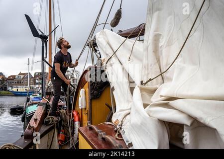 La nave a vela da carico «Tres Hombres» della compagnia marittima «Fairtransport» è ormeggiata nel suo porto di origine a Den Helder, Paesi Bassi, e salpa le vele. Qui viene preparato dall'equipaggio per il suo prossimo viaggio. La goletta 'Tres Hombres' trasporta merci come vino, caffè, cioccolato e rum dai Caraibi attraverso l'Atlantico all'Europa in un modo completamente neutro dal clima. Foto Stock