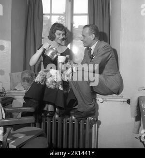 Negli anni '1950s. Gli attori Maj-Britt Nilsson e Hasse Ekman godono di una tazza di caffè durante una pausa durante le riprese di un film. Gli versa il caffè da una caffettiera in alluminio. Svezia 1953 Kristoffersson Rif. BL42-7 Foto Stock