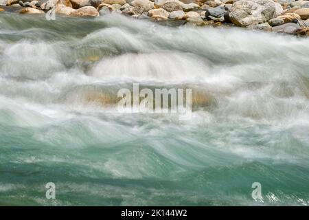 Rapide di Turbulent River. Un freddo e limpido torrente di montagna che scorre su massi nel nord-ovest del Pacifico. Sfocatura del movimento a esposizione lunga. Foto Stock