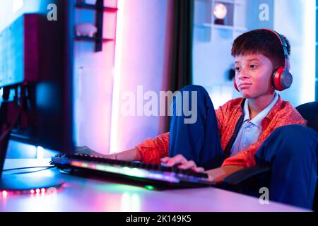 Annoiato sonno giovane adolescente ragazzo durante il gioco di video gioco online sul computer a casa - concetto di pigrizia, insonnia e solitudine. Foto Stock