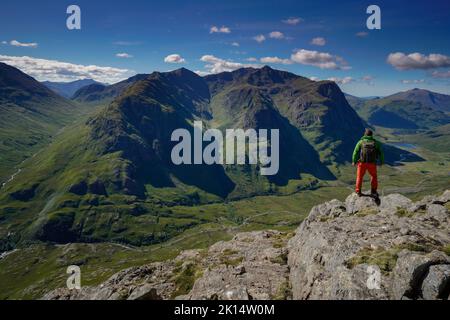 Un escursionista che guarda verso le tre sorelle di Glencoe, Highlands Scozia. Foto Stock