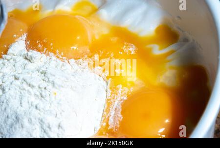 Farina e uova. Preparazione della pasta per la cottura a casa prima di Natale. Prodotti per la cottura in casa preparati per la miscelazione. Foto Stock