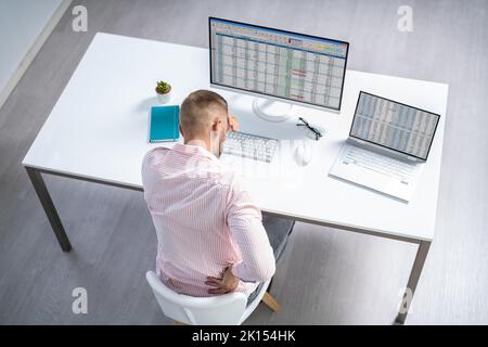 Mal di schiena cattiva postura uomo seduto in ufficio Foto Stock