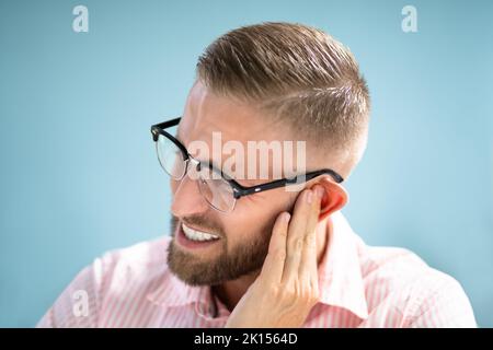 Dolore e dolore all'orecchio. Uomo infelice con otite externa Foto Stock