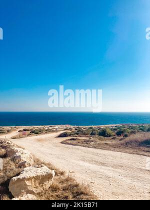 Pista sterrata che scende al mare e una spiaggia sulla baia di Famagosta vicino ad Ayia Napa, Cipro Foto Stock