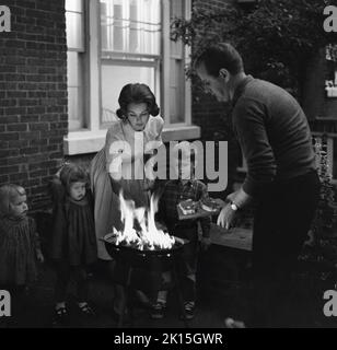 Una famiglia si riunisce per un barbecue sul cortile. 1956. Foto Stock