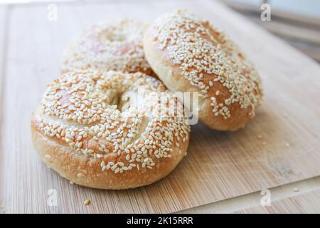 Bagel di sesamo freschi fatti in casa su un tagliere Foto Stock