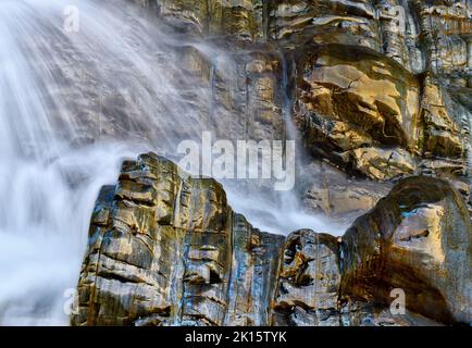 Ruscello di acqua pulita che scorre su rocce sedimentarie bagnate in estate in campagna in lunga esposizione Foto Stock