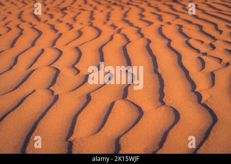 Sfondo a cornice pieno di superficie di sabbia ondulata su spiaggia arida al tramonto in natura Foto Stock
