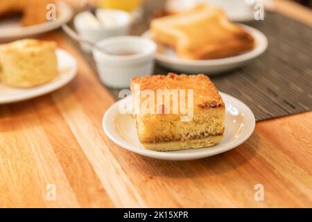 Piatto con torta di yummy messo sul tavolo durante la prima colazione in caffetteria Foto Stock