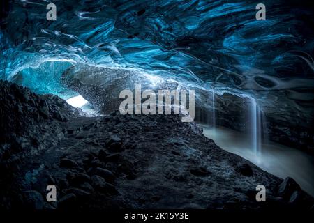 Grotta di ghiaccio Skaftadell con pareti blu ruvide e ruscello nella fredda giornata invernale in Islanda Foto Stock