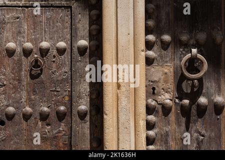 Vista frontale dell'ingresso principale del Monastero di Sant Cugat del Vallès (Spagna), un'abbazia benedettina. Dettagli di antiche porte medievali in legno. Foto Stock