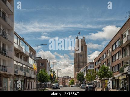 Europa, Francia, Dunkerque - 9 luglio 2022: Saint Eloi Belfry, in pietra marrone, domina la via dello shopping Rue Clemenceau sotto il paesaggio blu Foto Stock